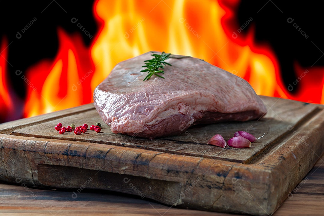 Picanha crua ou lombo de cima em uma tábua com fundo de fogo