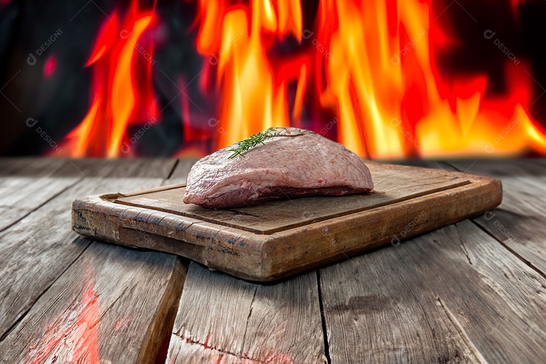 Picanha crua ou lombo de cima em uma tábua com fundo de fogo