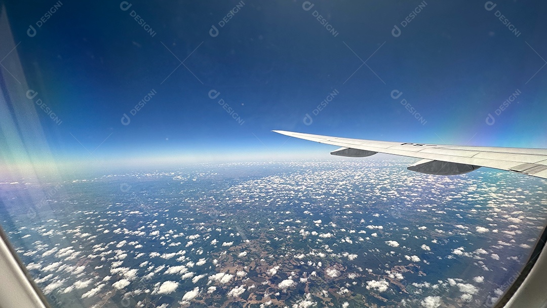 Foto da paisagem verde brasileira e do céu nublado tirada de avião