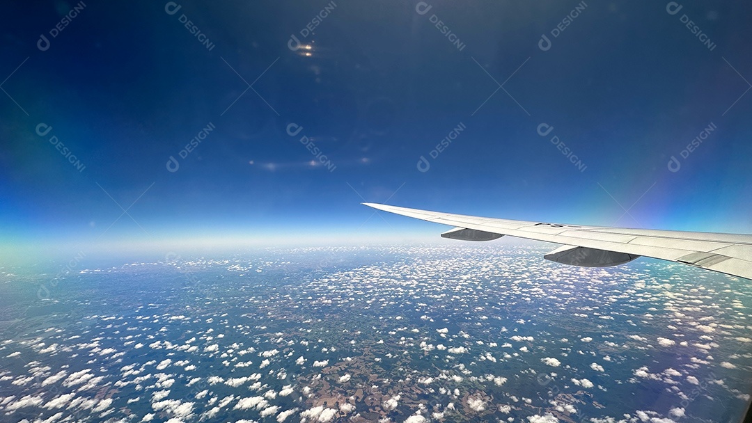 Foto da paisagem verde brasileira e do céu nublado tirada de avião