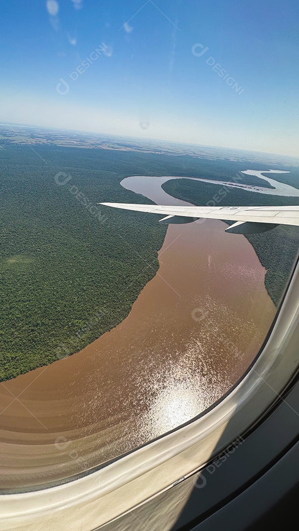 Foto da paisagem verde brasileira e do céu nublado tirada de avião