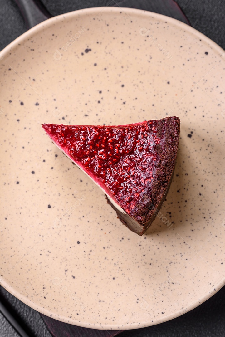 Delicioso bolo de cheesecake doce com queijo mascarpone, framboesas e geléia em um fundo escuro de concreto