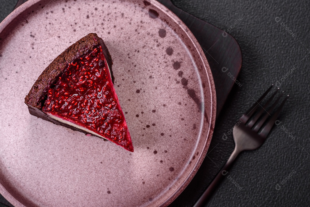 Delicioso bolo de cheesecake doce com queijo mascarpone, framboesas e geléia em um fundo escuro de concreto