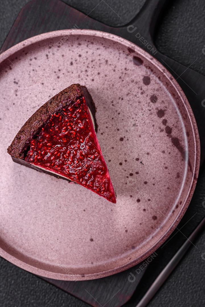 Delicioso bolo de cheesecake doce com queijo mascarpone, framboesas e geléia em um fundo escuro de concreto