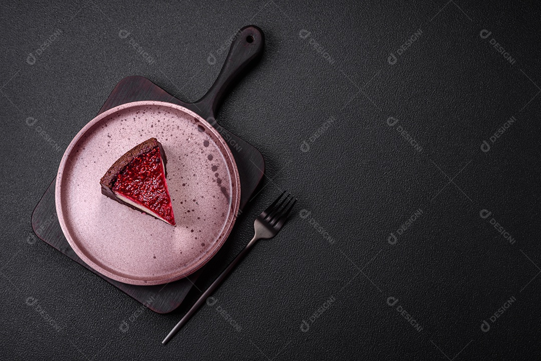 Delicioso bolo de cheesecake doce com queijo mascarpone, framboesas e geléia em um fundo escuro de concreto