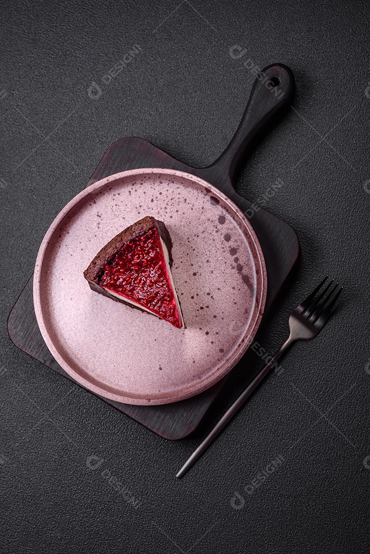 Delicioso bolo de cheesecake doce com queijo mascarpone, framboesas e geléia em um fundo escuro de concreto
