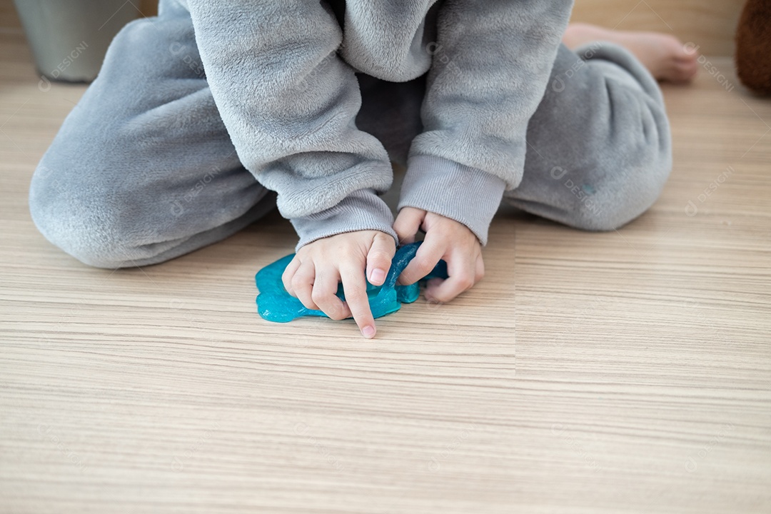 Menino asiático lindo brincando de amoeba na sala