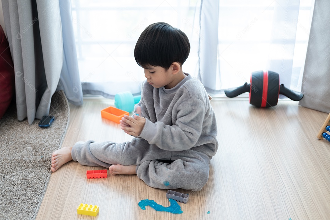 Menino lindo asiático brincando com e slam na sala