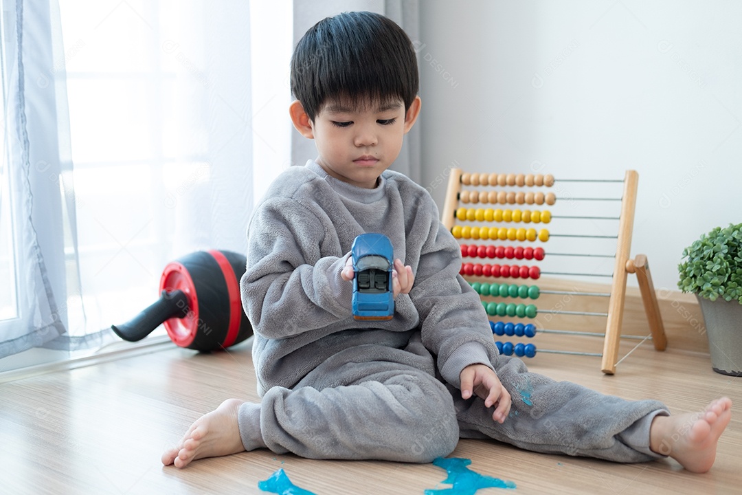 Menino lindo asiático brincando com e slam na sala