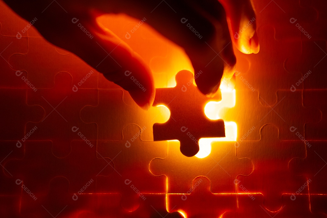 Peças de um quebra-cabeça cheio de luzes laranja à mão