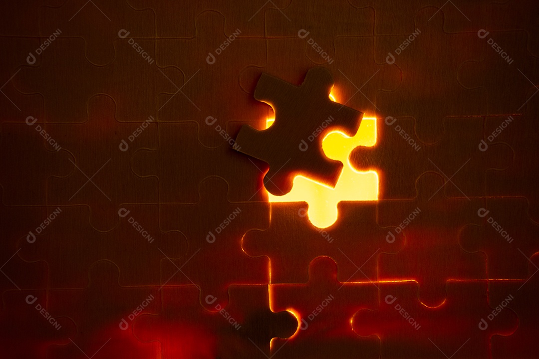 Peças de um quebra-cabeça cheio de luzes laranja à mão