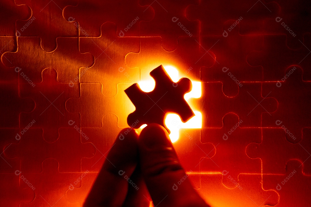 Peças de um quebra-cabeça cheio de luzes laranja à mão