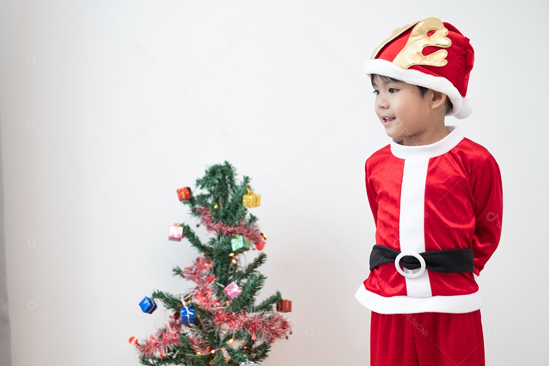 Menino asiático vestindo fantasia de Papai Noel