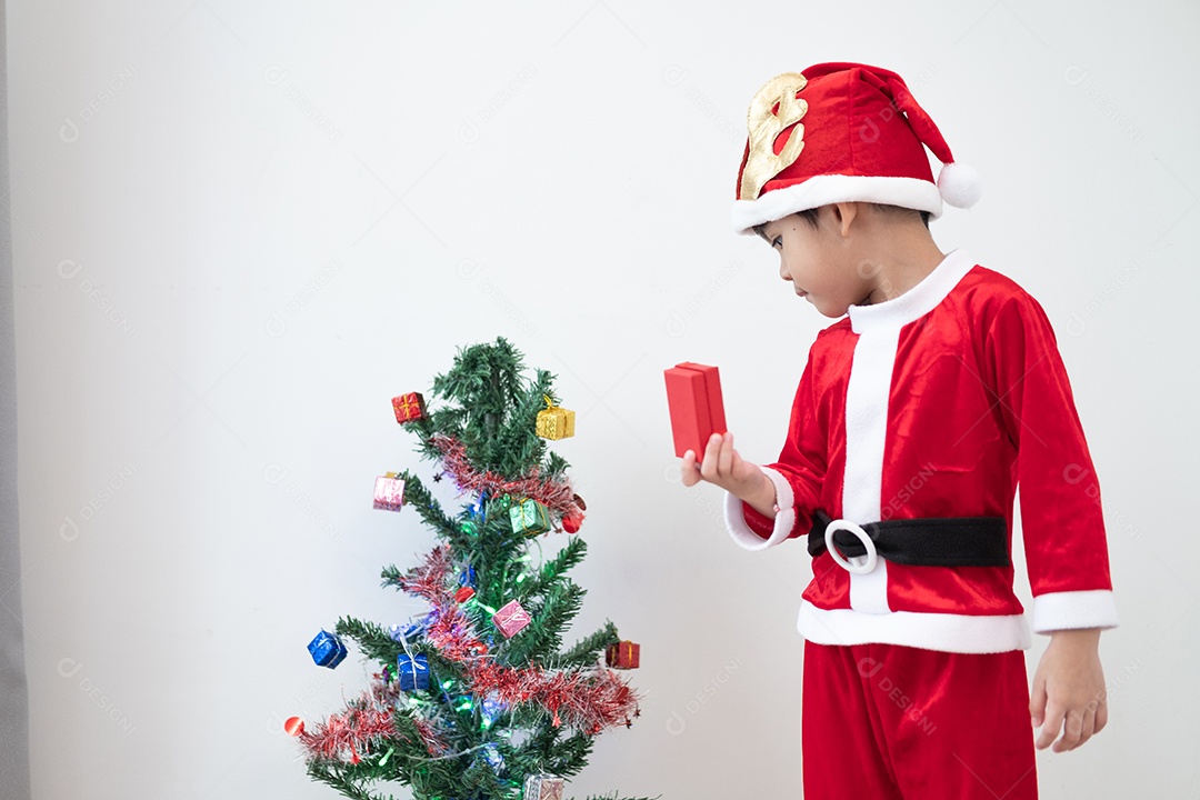 Menino asiático vestindo fantasia de Papai Noel