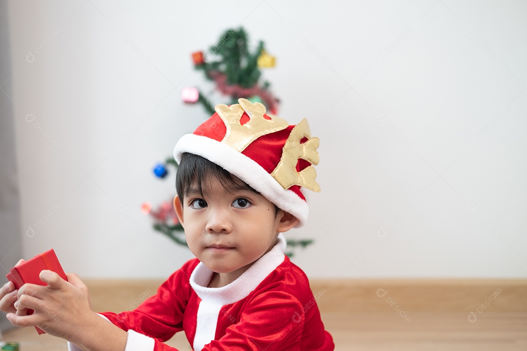 Menino asiático vestindo fantasia de Papai Noel