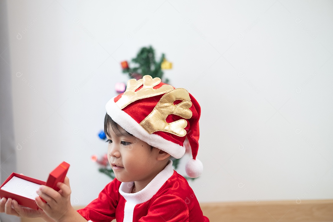 Menino asiático vestindo fantasia de Papai Noel