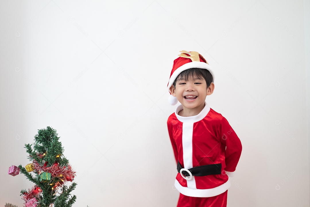 Menino asiático vestindo fantasia de Papai Noel