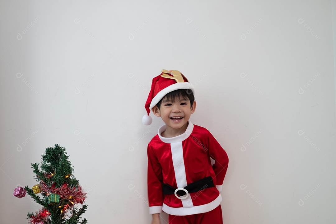 Menino asiático vestindo fantasia de Papai Noel