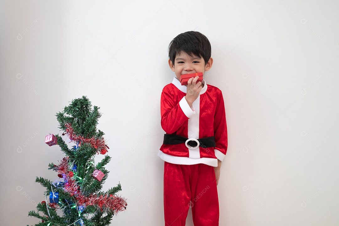 Menino asiático vestindo fantasia de Papai Noel