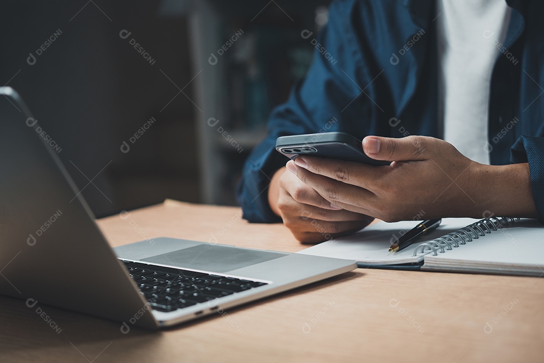 homem usando telefone inteligente móvel e trabalhando em laptop computer.education e conceito de tecnologia