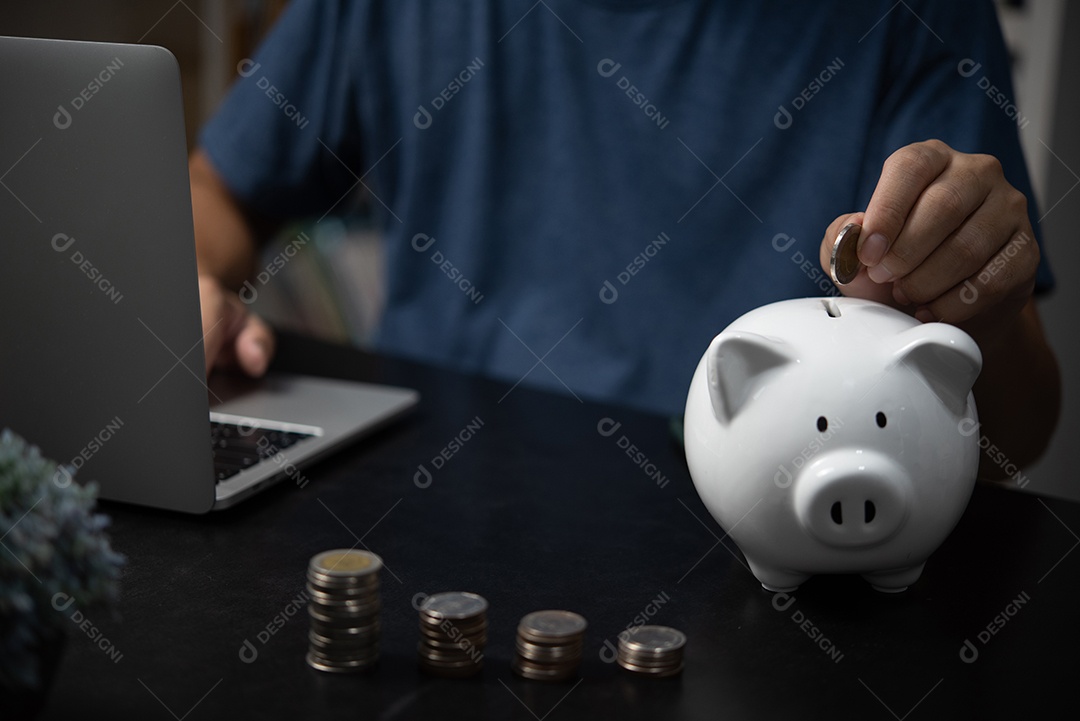 homem segurando moedas e cofrinho com computador portátil. Finanças empresariais, poupança, investimento