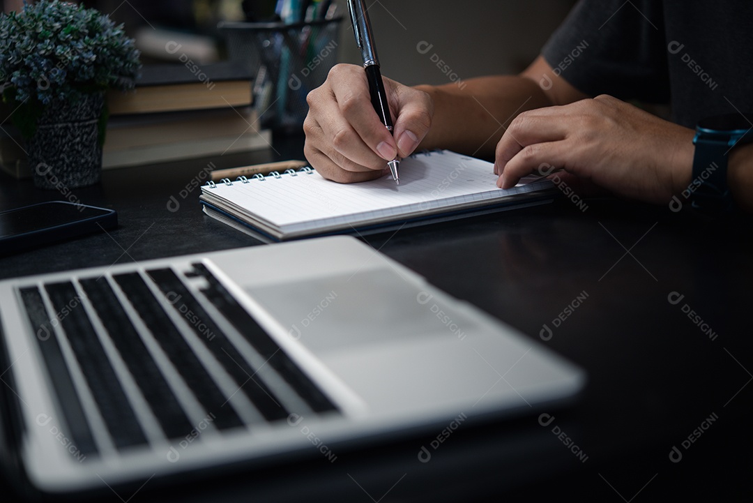 Homem digitando no teclado do computador portátil, procurando informações ou fazendo trabalho freelance.