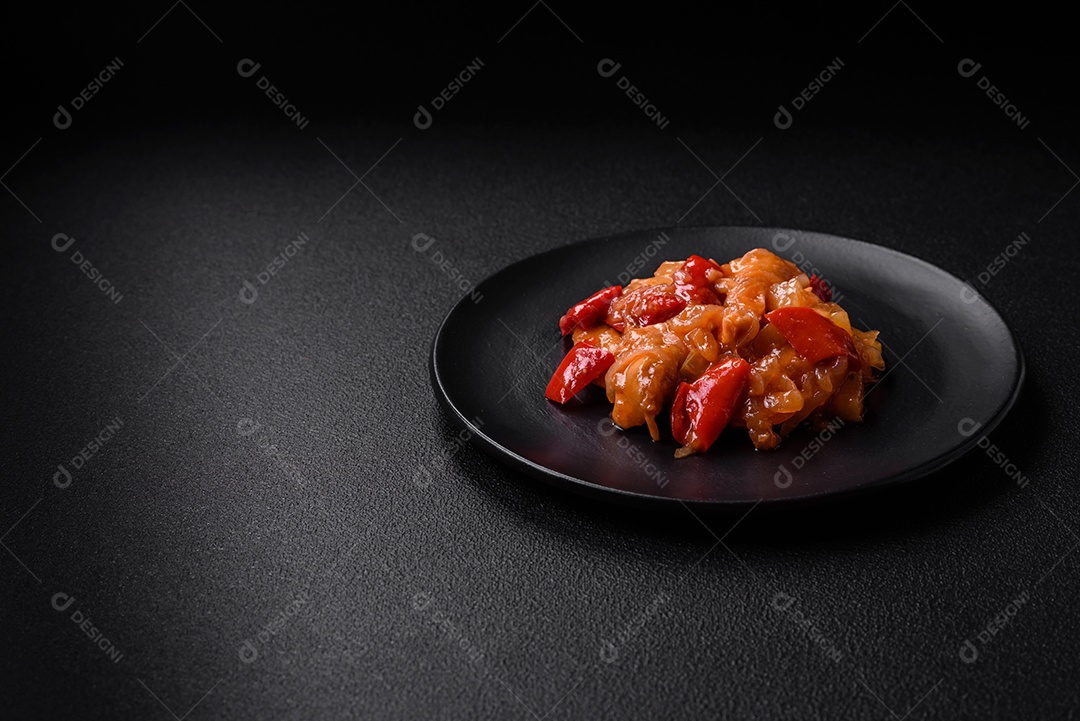 Deliciosa salada fresca com fatias de frango grelhado, abacaxi, pimentão, nozes e molho em um prato de cerâmica sobre um fundo escuro de concreto