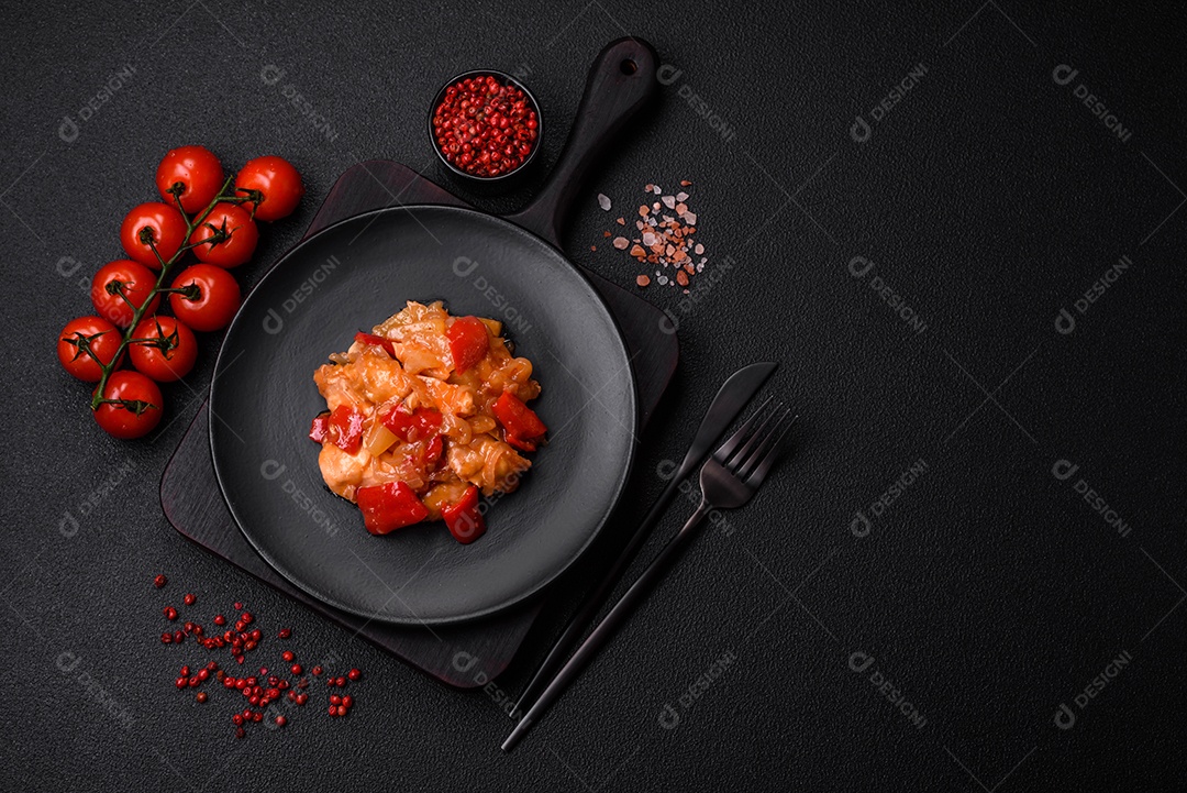 Deliciosa salada fresca com fatias de frango grelhado, abacaxi, pimentão, nozes e molho em um prato de cerâmica sobre um fundo escuro de concreto