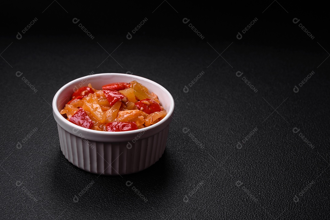 Deliciosa salada fresca com fatias de frango grelhado, abacaxi, pimentão, nozes e molho em um prato de cerâmica sobre um fundo escuro de concreto