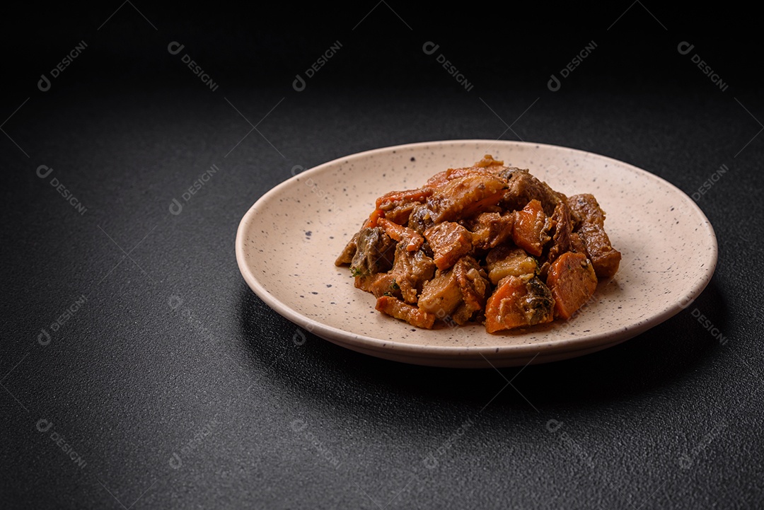 Deliciosa salada fresca com fatias de frango grelhado, abacaxi, pimentão, nozes e molho em um prato de cerâmica sobre um fundo escuro de concreto