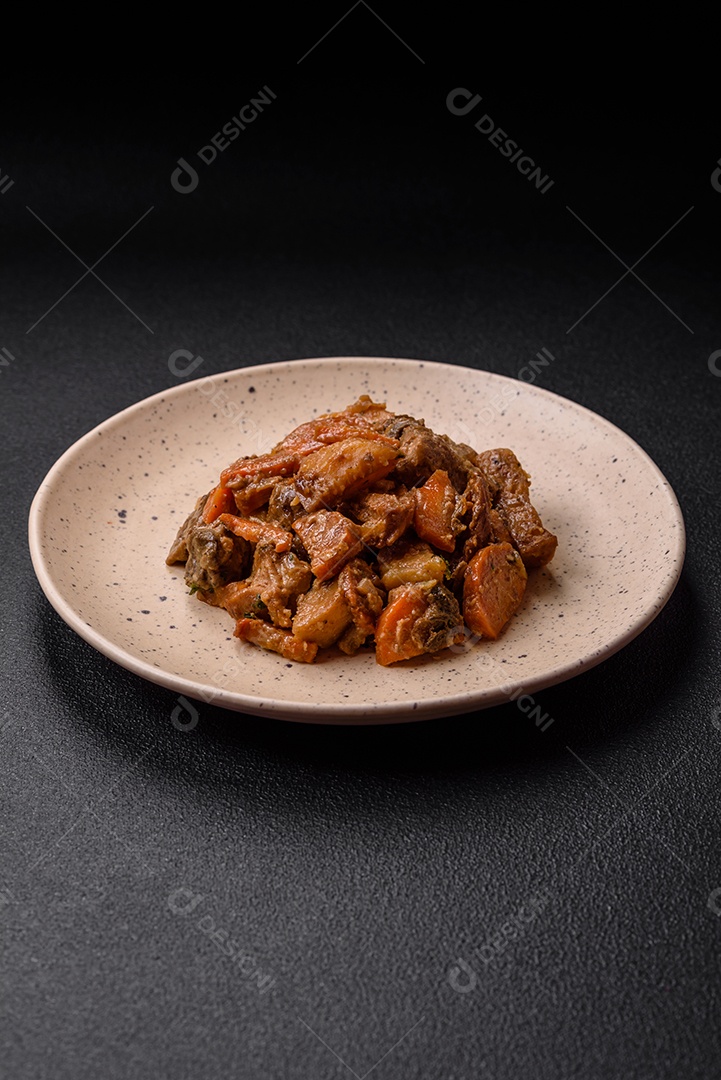 Deliciosa salada fresca com fatias de frango grelhado, abacaxi, pimentão, nozes e molho em um prato de cerâmica sobre um fundo escuro de concreto
