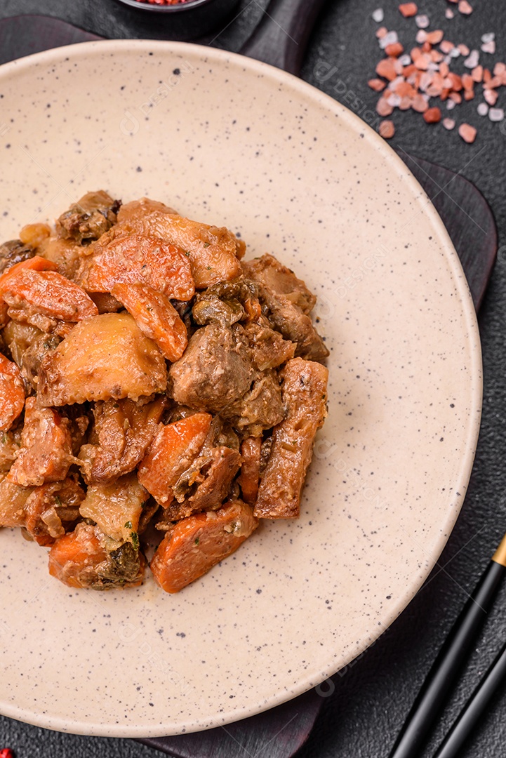 Deliciosa salada fresca com fatias de frango grelhado, abacaxi, pimentão, nozes e molho em um prato de cerâmica sobre um fundo escuro de concreto
