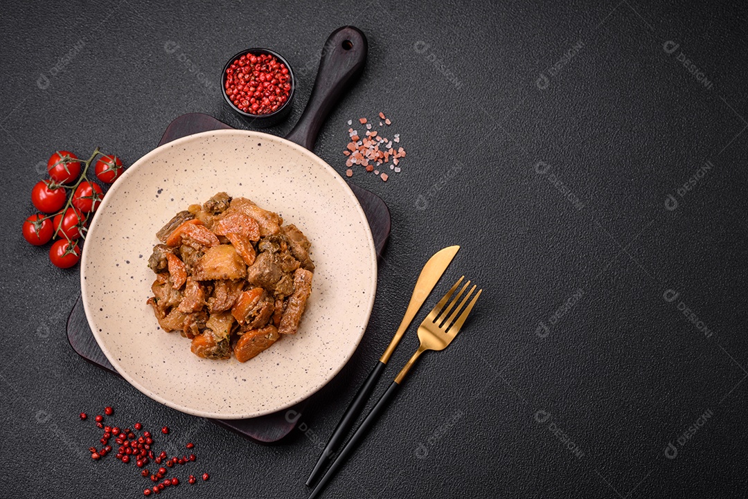 Deliciosa salada fresca com fatias de frango grelhado, abacaxi, pimentão, nozes e molho em um prato de cerâmica sobre um fundo escuro de concreto