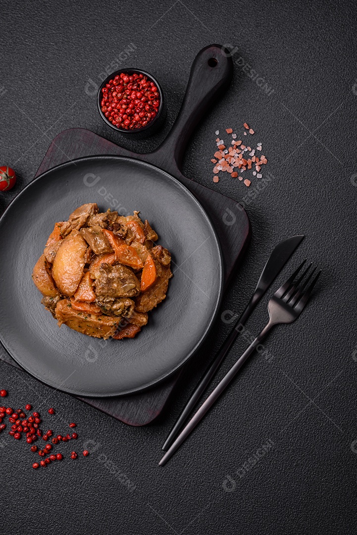 Deliciosa salada fresca com fatias de frango grelhado, abacaxi, pimentão, nozes e molho em um prato de cerâmica sobre um fundo escuro de concreto