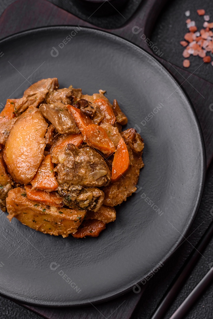 Deliciosa salada fresca com fatias de frango grelhado, abacaxi, pimentão, nozes e molho em um prato de cerâmica sobre um fundo escuro de concreto