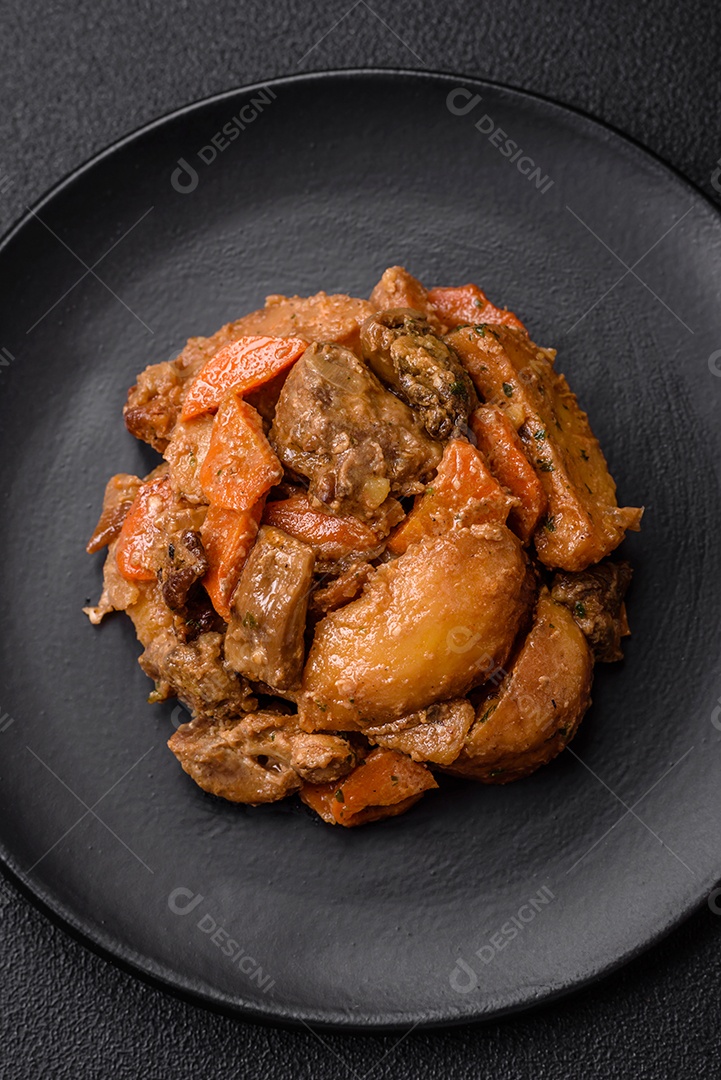 Deliciosa salada fresca com fatias de frango grelhado, abacaxi, pimentão, nozes e molho em um prato de cerâmica sobre um fundo escuro de concreto