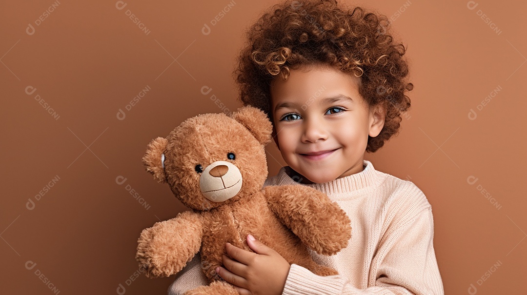 Garoto negro com roupas casuais se diverte, abraça o ursinho de pelúcia