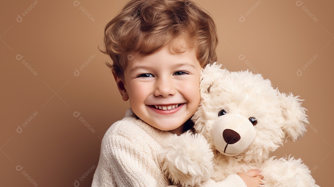 Garoto branco em roupas casuais se diverte, abraça o ursinho de pelúcia
