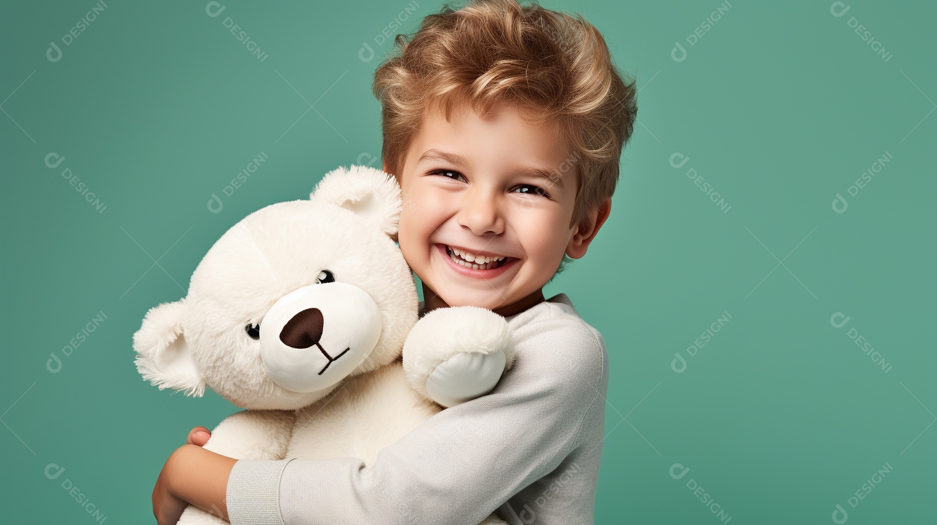 Garoto branco em roupas casuais se diverte, abraça o ursinho de pelúcia