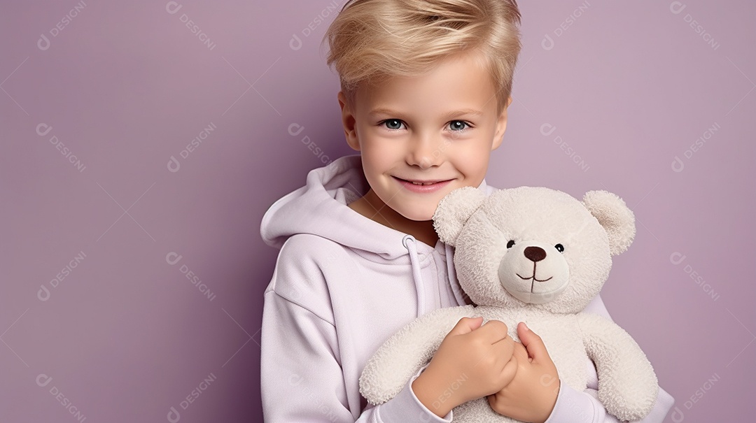 Garoto branco em roupas casuais se diverte, abraça o ursinho de pelúcia