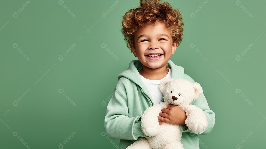 Garoto branco em roupas casuais se diverte, abraça o ursinho de pelúcia
