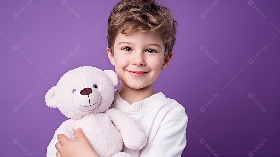 Garoto branco em roupas casuais se diverte, abraça o ursinho de pelúcia