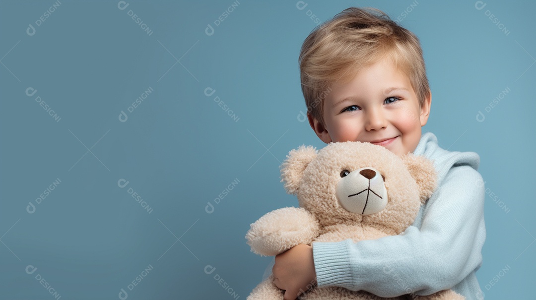 Garoto branco em roupas casuais se diverte, abraça o ursinho de pelúcia