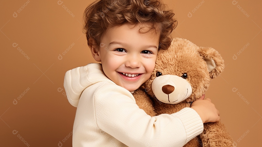 Garoto branco em roupas casuais se diverte, abraça o ursinho de pelúcia