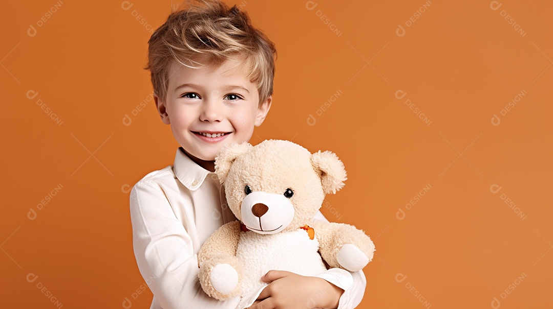 Garoto branco em roupas casuais se diverte, abraça o ursinho de pelúcia