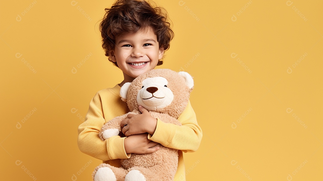 Garoto branco em roupas casuais se diverte, abraça o ursinho de pelúcia