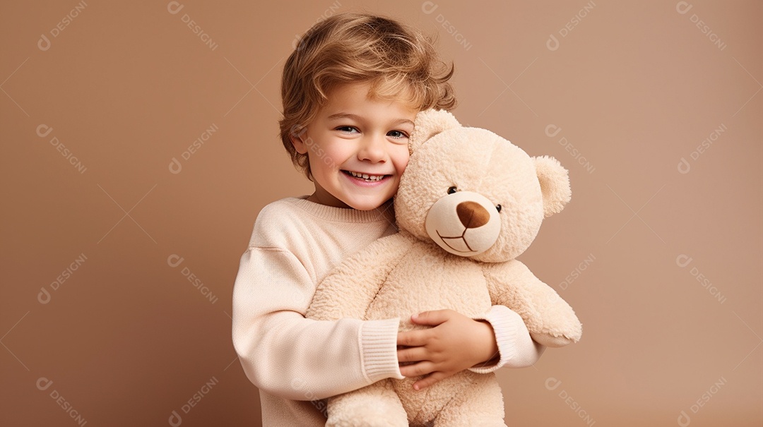 Garoto branco em roupas casuais se diverte, abraça o ursinho de pelúcia