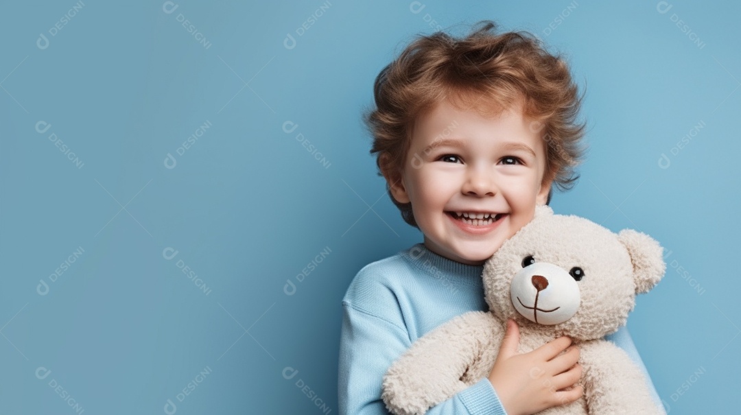 Garoto branco em roupas casuais se diverte, abraça o ursinho de pelúcia