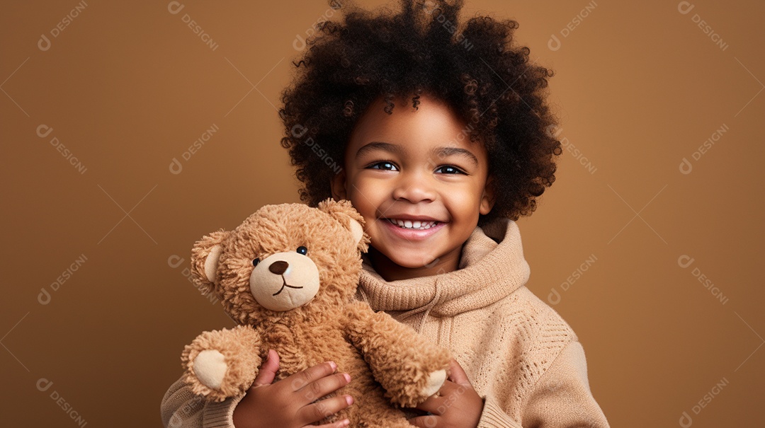 Garoto negro com roupas casuais se diverte, abraça o ursinho de pelúcia