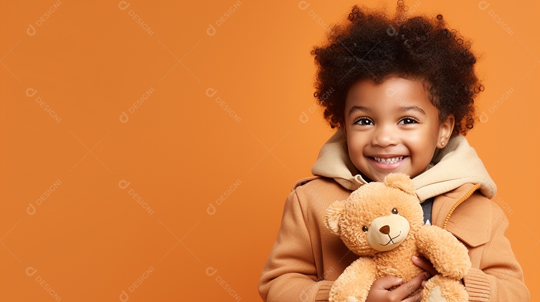 Garoto negro com roupas casuais se diverte, abraça o ursinho de pelúcia